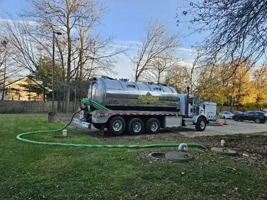 Black Diamond tanker on a residential lawn with the hose run out to the septic lids